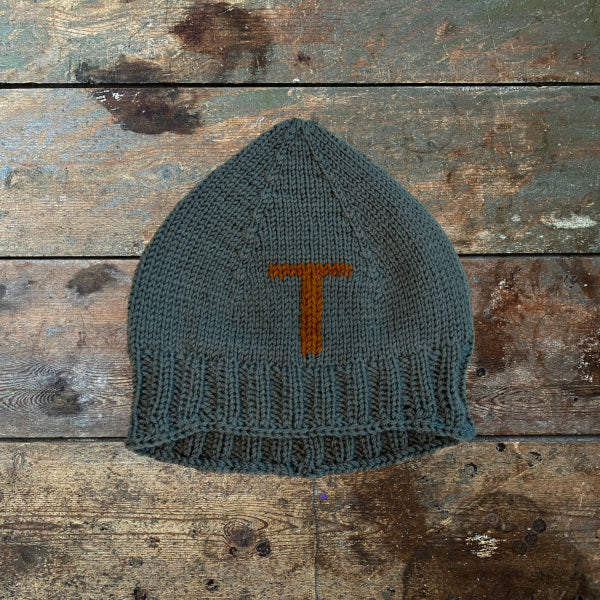 Strikkeopskrift elastisk børnehue med broderet bogstav. Strikket på pind 4 i 2 tråde strømpegarn. Broderet bogstav forrest på huen