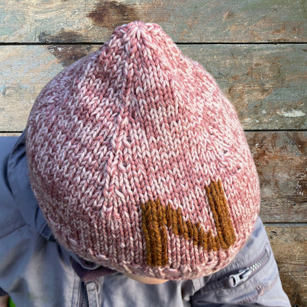 Strikkeopskrift elastisk børnehue med broderet bogstav. Strikket på pind 4 i 2 tråde strømpegarn. Broderet bogstav forrest på huen. Bogstavsdiagrammer  med opskriften